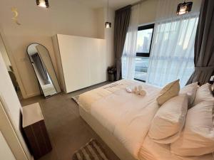 a large bed in a room with a large window at 1BR Americana Apartment: Stars and Stripes Haven in Abu Dhabi