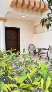 two chairs and a table in front of a building at Chic 3-BR Tala Almajd Villas in upscale district Alnahdah Family only in Jeddah