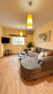 sala de estar con sofá y TV en Chic 3-BR Tala Almajd Villas in upscale district Alnahdah Family only, en Yeda