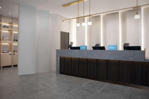 an office lobby with a reception counter and tables at Hilton Arlington National Landing in Arlington