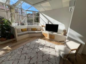 een woonkamer met een bank en een tv bij Bord de mer, magnifique appartement de 150m2 avec jardin in Marseille