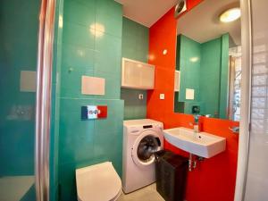 uma casa de banho com uma máquina de lavar roupa e um lavatório em Przyjemne studio na Muranowie em Varsóvia