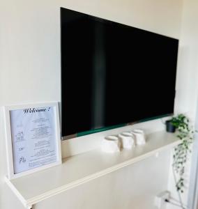 einen Flachbild-TV auf einem weißen Regal in der Unterkunft Scandinavian design 2BR @ Ortigas, Pasig in Manila
