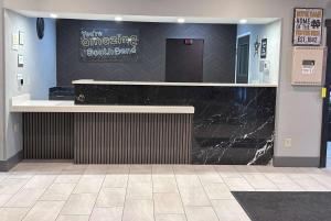 a lobby with a black counter in a building at La Quinta by Wyndham South Bend in South Bend