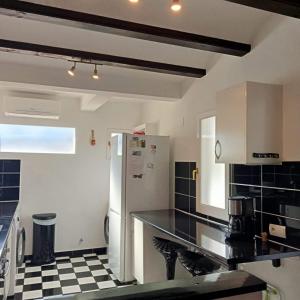 uma cozinha com um frigorífico e um piso em xadrez preto e branco em Casa del Toro em Els Poblets