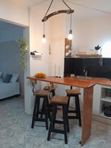 kuchnia z drewnianym stołem i kilkoma stołkami w obiekcie Palermo Embassy w BuenosAires