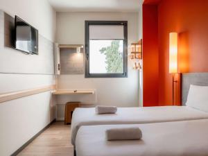 Una habitación de hotel con dos camas y una ventana. en Ibis Budget Madrid Centro Lavapies, en Madrid