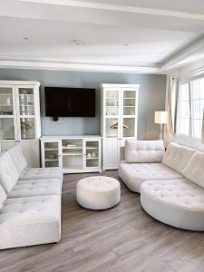 een woonkamer met twee witte banken en een tv bij Luxurious Penthouse Studio with Private Terrace - Grand Central House in Gibraltar