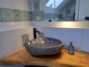a bathroom with a bowl sink on a wooden counter at Gemütliche Waldrandlage in Badenweiler Sehringen Ferienwohnung in Badenweiler
