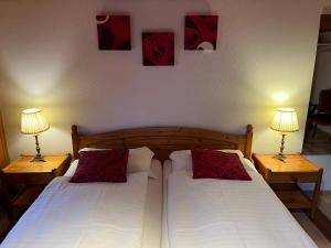 a bedroom with two twin beds with two lamps at Historic Hotel Steinbock in Wilderswil