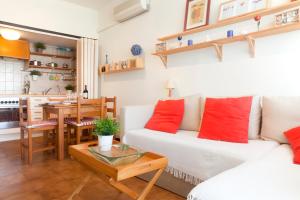 een woonkamer met een witte bank en een tafel bij Spot beachfront apartment minimun rent one month in Vilanova i la Geltrú
