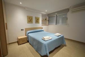 a bedroom with a blue bed with two towels on it at MAR Y VENT 5A - Fincas Arena in Benidorm