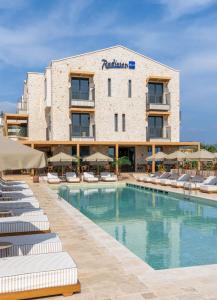 a hotel with a swimming pool and lounge chairs at Radisson Blu Hotel, Kas in Kaş