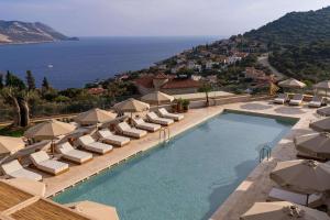 a swimming pool with chairs and umbrellas at Radisson Blu Hotel, Kas in Kaş