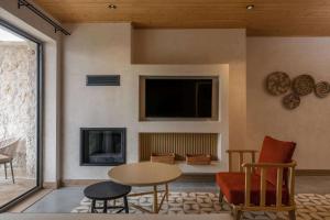 a living room with a table and chairs and a tv at Radisson Blu Hotel, Kas in Kaş