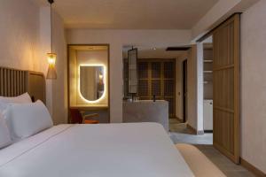 Radisson Blu Hotel, Kas في كاس: غرفة نوم بسرير ابيض وحمام