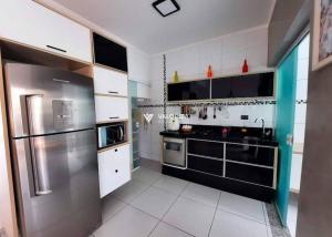 uma cozinha com um frigorífico de aço inoxidável e armários brancos em Lindo aconchego do Interior. em Sorocaba
