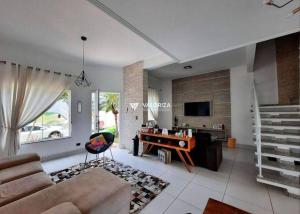 a living room with a couch and a desk at Lindo aconchego do Interior. in Sorocaba