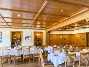 una sala da pranzo con tavoli e sedie bianchi di Landgasthof Jostalstüble a Titisee-Neustadt