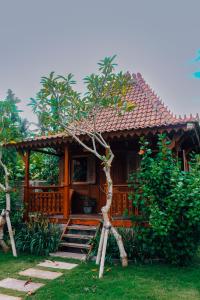 una casa de madera con escaleras en un jardín en Nunu Bali Eco Friendly Retreat, en Canggu