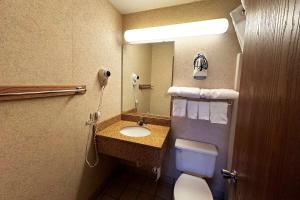 y baño con lavabo, aseo y espejo. en Travelodge by Wyndham Rapid City - Black Hills, en Rapid City