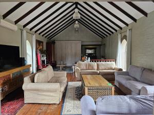 a living room with couches and a flat screen tv at Castle Home in Centurion