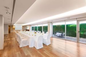 um quarto grande com uma grande mesa branca com cadeiras brancas em Doubletree By Hilton Buenos Aires em Buenos Aires