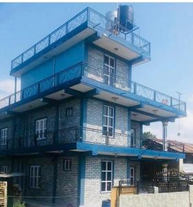 un edificio azul con una torre con balcón en Three daughters family home, en Pokhara