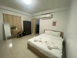 - une chambre avec un lit et des serviettes dans l'établissement Grand Bangsaen Hotel, à Bang Saen