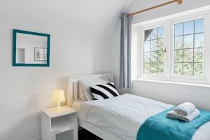 um quarto branco com uma cama e uma janela em Spacious 4 Bedroom House with Lovely Large Garden em Nottingham