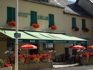 a building with red umbrellas in front of a restaurant at Hôtel Restaurant Anglade in Le Nayrac