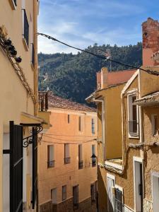 an alley between two buildings with mountains in the background at Casa Rural Hoyo del moro in Liétor