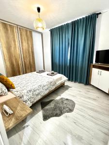 a bedroom with a bed and blue curtains at New cozy apartment in Otopeni near airport in Otopeni