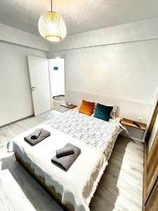 um quarto com uma cama grande e toalhas em New cozy apartment in Otopeni near airport em Otopeni