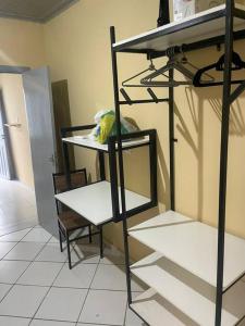 a room with a shelf and a table and a chair at Apto 2 otimo local proximo shopping in Campo Grande