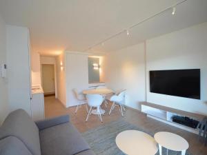 sala de estar con sofá y mesa con sillas en Plaza H0733 with beautiful side sea view, en Oostduinkerke