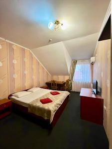 - une chambre avec un lit et des serviettes rouges dans l'établissement Domino, à Berehove