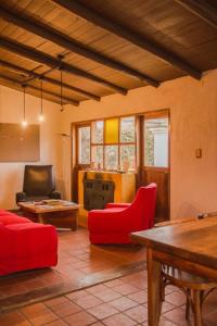 a living room with red chairs and a table at Finca La Pichona in Los Árboles