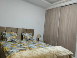 1 dormitorio con 1 cama con flores azules y amarillas en Résidence djerba 4, en Houmt El Souk