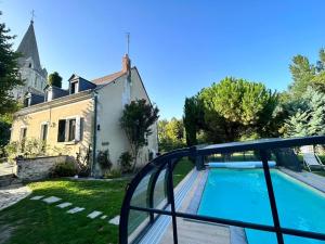 uma vista a partir da varanda de uma casa com piscina em Le Clos du Tilleul Fabuleuse propriété 15 à 30 Pers Piscine au coeur d'un charmant village em Thilouze