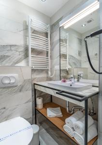 a bathroom with a sink and a toilet at Noir Hotel in Szeged