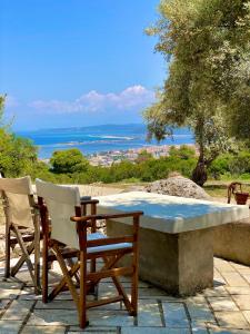 einen Tisch und Stühle mit Meerblick in der Unterkunft Olive Grove Cottage - Excellent View in Lefkada Town