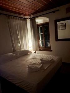 1 dormitorio con 1 cama con 2 toallas en Xinovrissi Apts & Pool, en Xinóvrisi