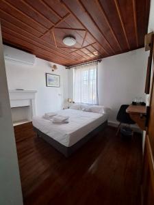 1 dormitorio con 1 cama grande y techo de madera en Xinovrissi Apts & Pool, en Xinóvrisi