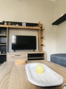 a living room with a table and a television at Central Family Apartment in Preveza