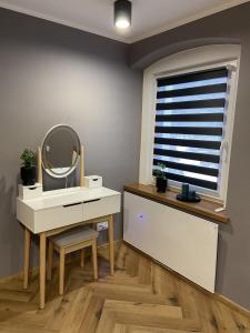 a bathroom with a sink and a mirror and a window at Apartament Rose Valley Dwa Zero in Szczytna