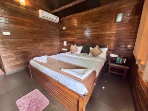 um quarto com uma cama grande numa parede de madeira em Melba Beach Resort By Maitree em Arambol