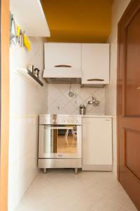 a kitchen with a stainless steel stove and white cabinets at Bologna Easy Explore - AmbrogioHost in Bologna