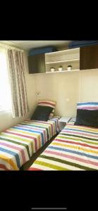 two beds sitting next to each other in a room at Holidays by juliano camping 5 etoiles 3149 in Grimaud
