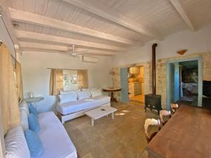 ein Wohnzimmer mit einem weißen Sofa und einem Tisch in der Unterkunft Olive Grove Cottage - Excellent View in Lefkada Town